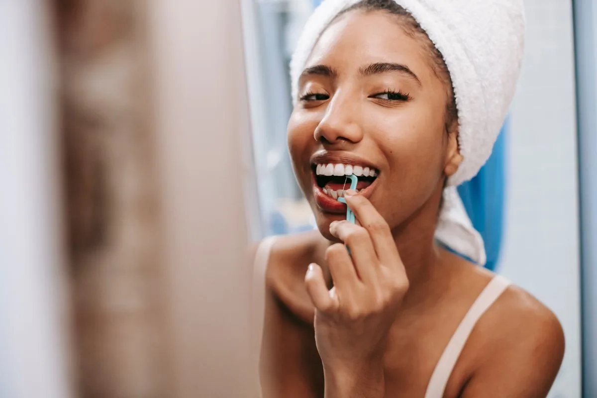 Woman flossing between her teeth at home