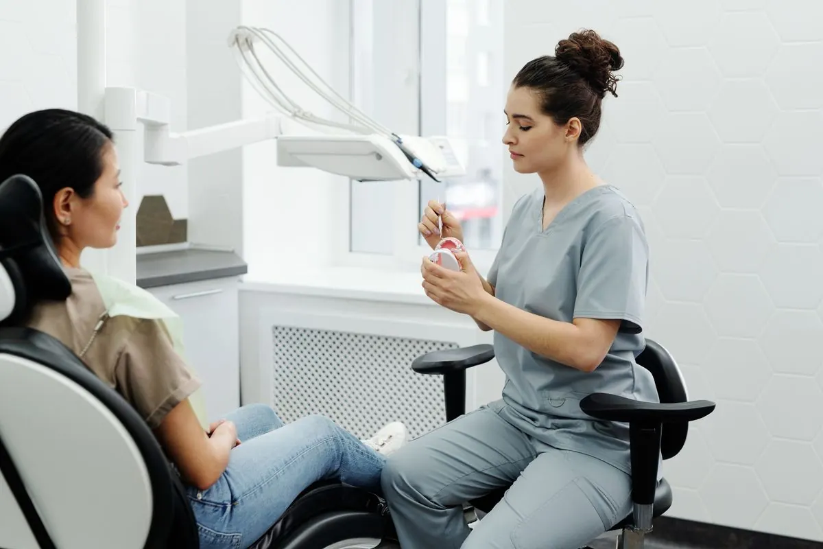 Dentist using a model to explain how dental implants work