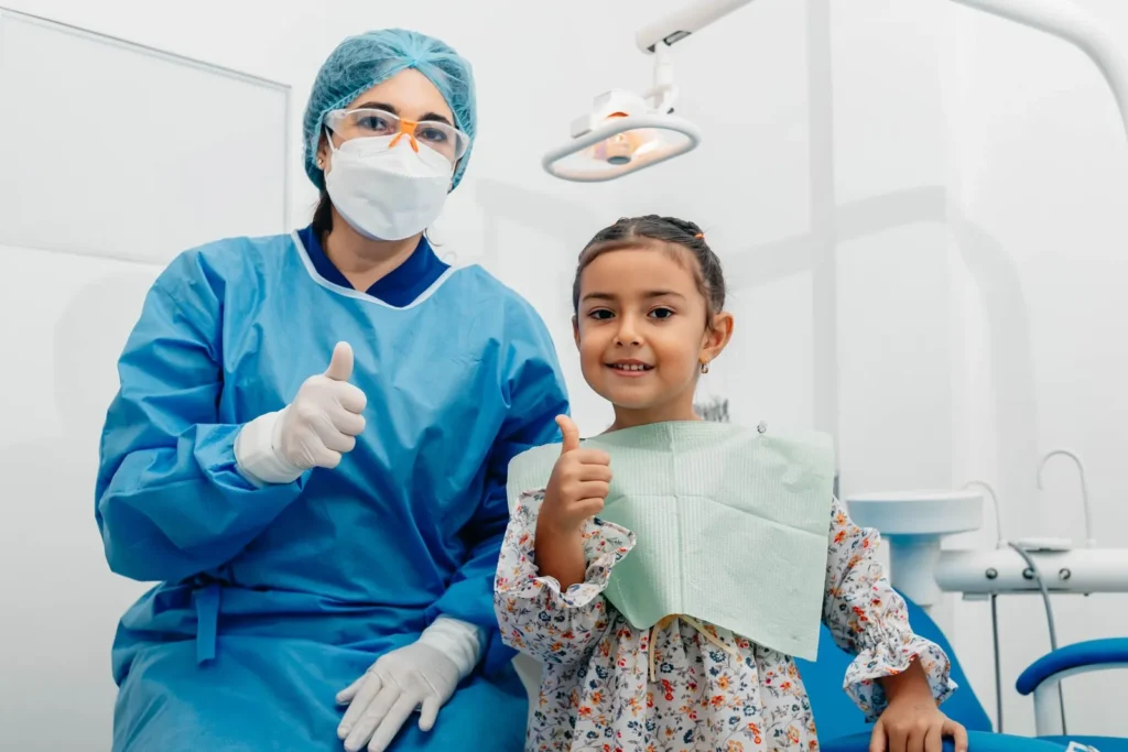 A child and dentist after a checkup in a bright dental office