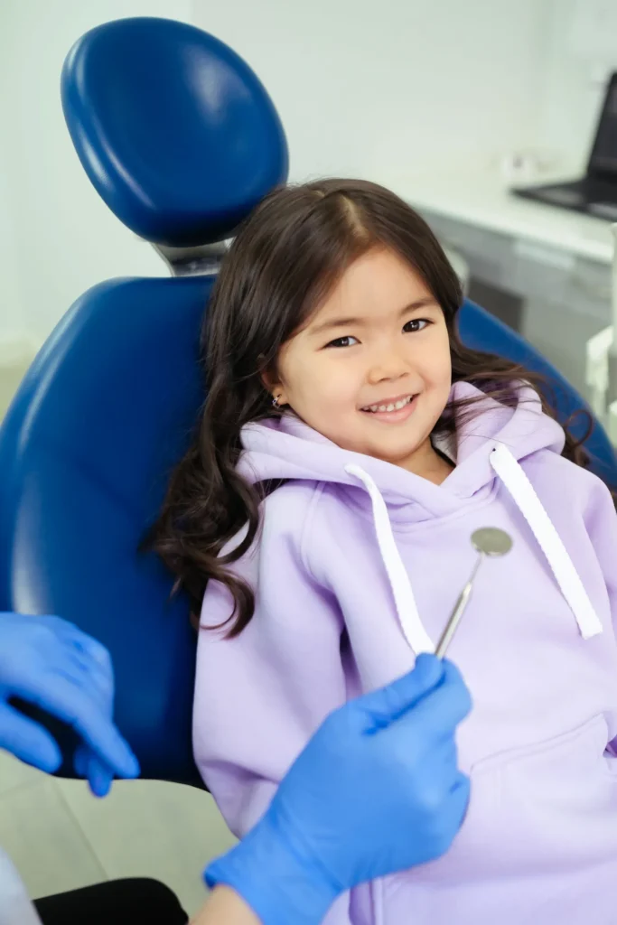 A smiling child in the dental chair during a visit