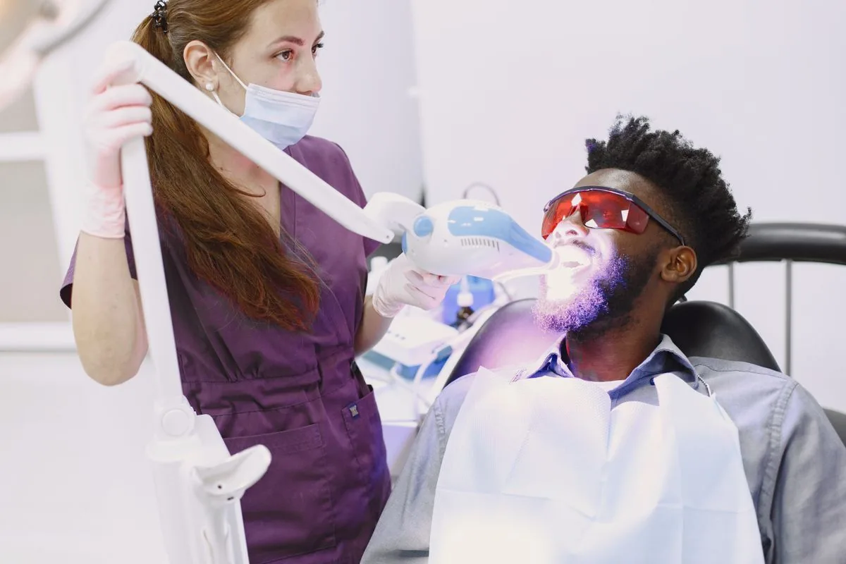 Dentist performing an in-office professional teeth whitening treatment